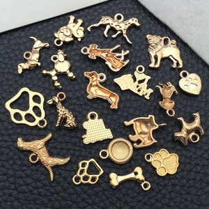 Detail of assorted golden dog charms, paw prints and bones on black leather background