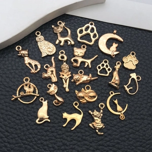 Pendentifs chat en alliage doré pour bijoux DIY sur une surface noire texturée élégante