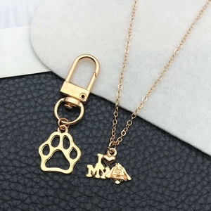Set d'accessoires dorés avec porte-clés patte ajourée et collier à portrait de chien