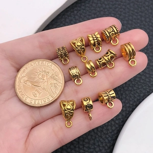 Macro detail of antique gold alloy beads with ornate patterns next to a one dollar coin