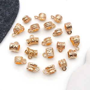 Macro shot of gold engraved slider beads with charms loops for jewelry making