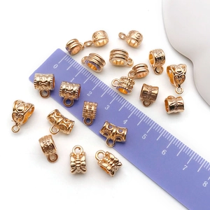 Macro view of gold-plated alloy pendant connectors and spacer beads with embossed texture