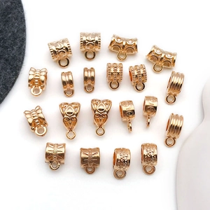 Macro view of assorted gold alloy bails with engraved patterns for DIY bracelet pendants