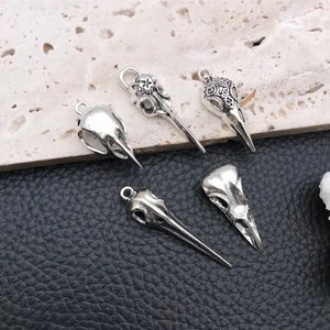 Detailed view of five gothic skull bird head pendants with vintage engraved patterns
