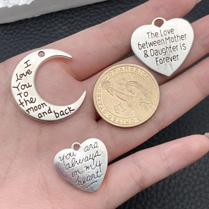 Silberne Herz- und Mondanhänger für DIY-Schmuck mit Münze als Größenvergleich