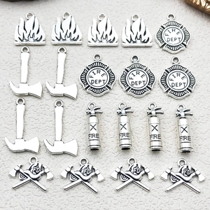 Detail of silver firefighter charms set with fire extinguisher and helmet pendants