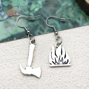 Detailed close-up of creative asymmetric fire fighter earrings with silver axe and flame charms