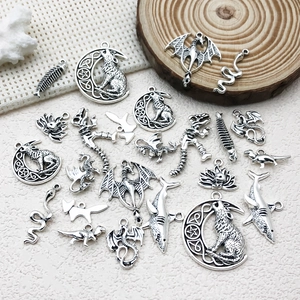 Macro view of vintage silver DIY animal charms including wolf moon and dragon for jewelry