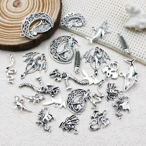 Close-up of antique silver alloy charms featuring mystical dragons, wolves and animal shapes