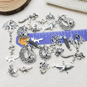 Assorted vintage silver animal pendants with ruler for scale in DIY jewelry set