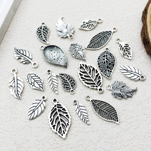 Gros plan de divers pendentifs en forme de feuille argentée vintage pour bijoux DIY