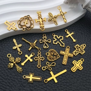 Macro view of various vintage gold alloy cross and heart pendants for DIY jewelry making