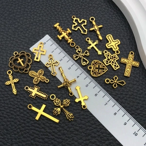 Detailed view of vintage gold cross alloy charms with ruler showing sizes for DIY jewelry