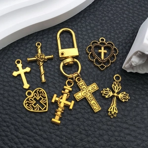 Vintage golden cross and heart charms set for DIY jewelry making on black leather