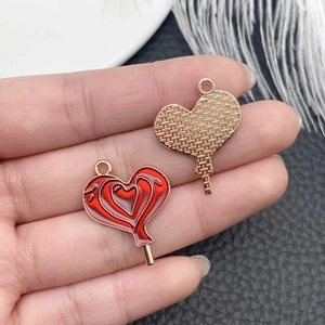 Macro view of a gold-plated red heart lollipop charm for DIY jewelry necklaces