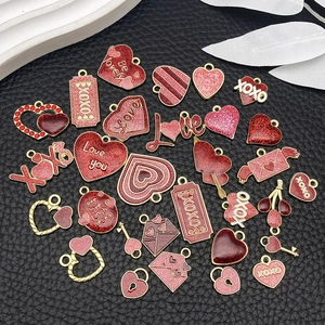 Detailed view of red and pink enamel heart charms on black leather for DIY jewelry making