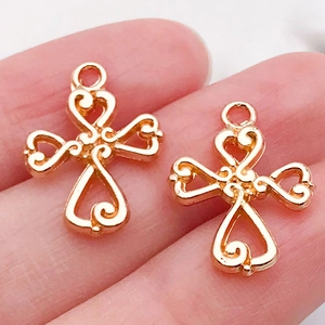 Close-up of small rose gold hollow cross charms for DIY jewelry and bracelet making