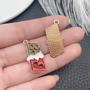 Detailed view of chocolate bar pendants with red hearts and golden textured backs