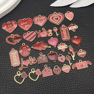 Macro shot of assorted red and pink enamel Valentine pendants on black leather background