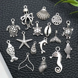 Macro detail of fifteen antique silver marine life charms on black leather background