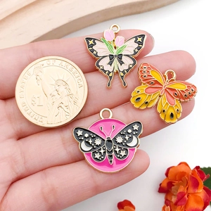 Detailed view of colorful butterfly charms next to a coin for size reference