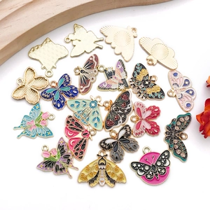 Flat lay of colorful enamel butterfly and moth alloy pendants for DIY jewelry making