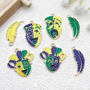 Detail of alloy carnival charms with smile mask and feather shapes in bright enamel colors