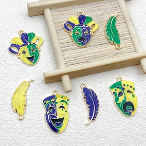 Detail of colorful Mardi Gras mask and feather charms with gold plating for jewelry making