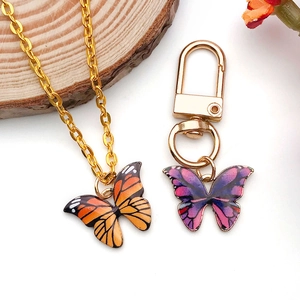 Detailansicht der Schmetterling-Halsketten und Schlüsselanhänger auf einem Naturholzgrund