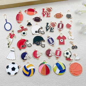Gros plan de pendentifs sportifs en émail incluant football, basket et raquettes de tennis