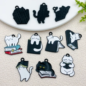 Detailed macro view of black and white enamel cat charms for DIY jewelry and crafts