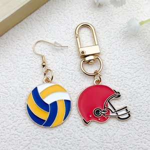 Détail de la boucle d'oreille volleyball et du porte-clés casque de football rouge