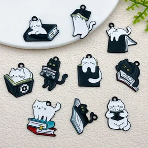 Detail of diverse cartoon enamel cat reading book charms for DIY jewelry and crafts