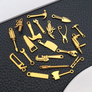 Macro view of assorted gold alloy mini tool charms including wrenches and hammers