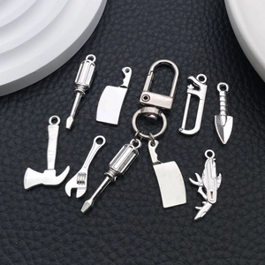 Pendentifs outils de bricolage argentés comprenant clés, haches et scies sur fond noir
