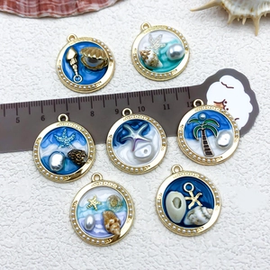Detail of ocean-themed starfish pendants featuring oil-dripped enamel and mini pearls