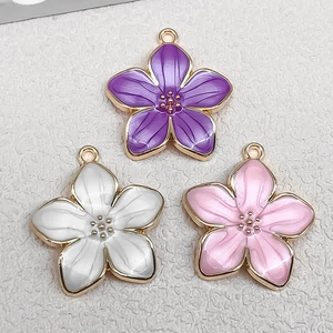 Detailed macro view of colorful enamel cherry blossom charms for DIY jewelry making