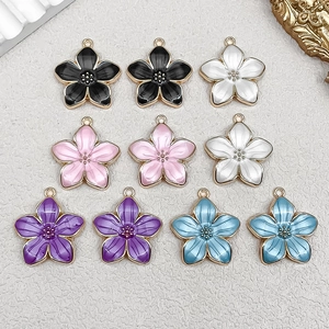Macro view of colorful enamel cherry blossom flower charms with golden alloy edges