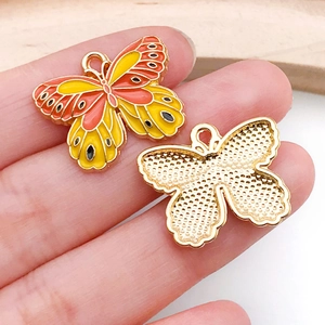 Macro detail of a colorful butterfly pendant made of gold alloy and enamel for DIY jewelry