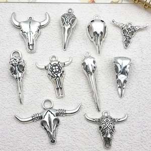 Macro view of vintage silver bull and bird skull alloy pendants for DIY jewelry making