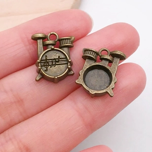 Macro detail of a vintage bronze drum kit charm with musical notes for DIY jewelry making