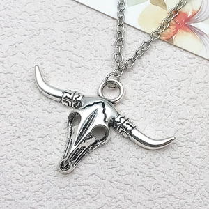 Macro shot of vintage silver bull skull pendant with ethnic patterns and o-chain