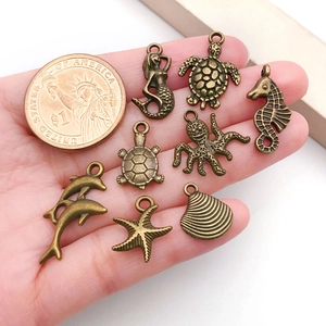 Détail des pendentifs marins en bronze antique avec une pièce pour comparer la taille