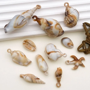 Macro detail of acrylic seashell and starfish charms with marble texture for DIY jewelry
