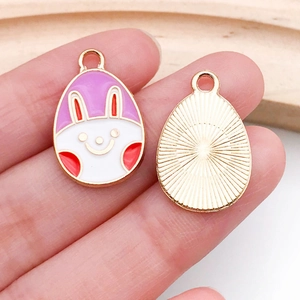 Pink Easter egg charm featuring white bunny design and golden metal textured back