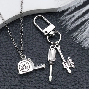 Detailed view of silver alloy pendants featuring tape measure, screwdriver and axe charms