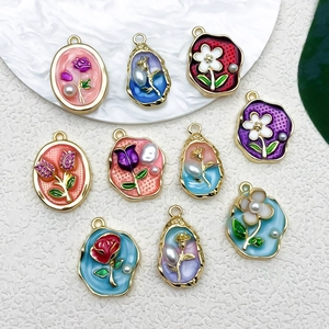 Macro detail of vintage floral enamel charms with gold frames and small pearls