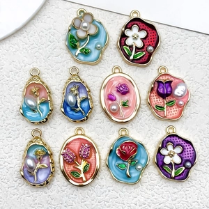 Macro detail of 10 colorful enamel flower charms with pearls for DIY jewelry making