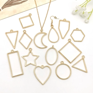 Makro-Detail verschiedener goldener geometrischer Metallanhänger für DIY-Schmuck und Bastelarbeiten