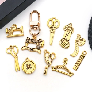 Vintage goudkleurige naaimachine en schaar bedeltjes voor DIY sieraden maken